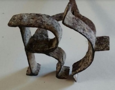 Hermann Rieck’s livestock branding iron, photographed head-on: the working face forms the letter R joined to a reversed C