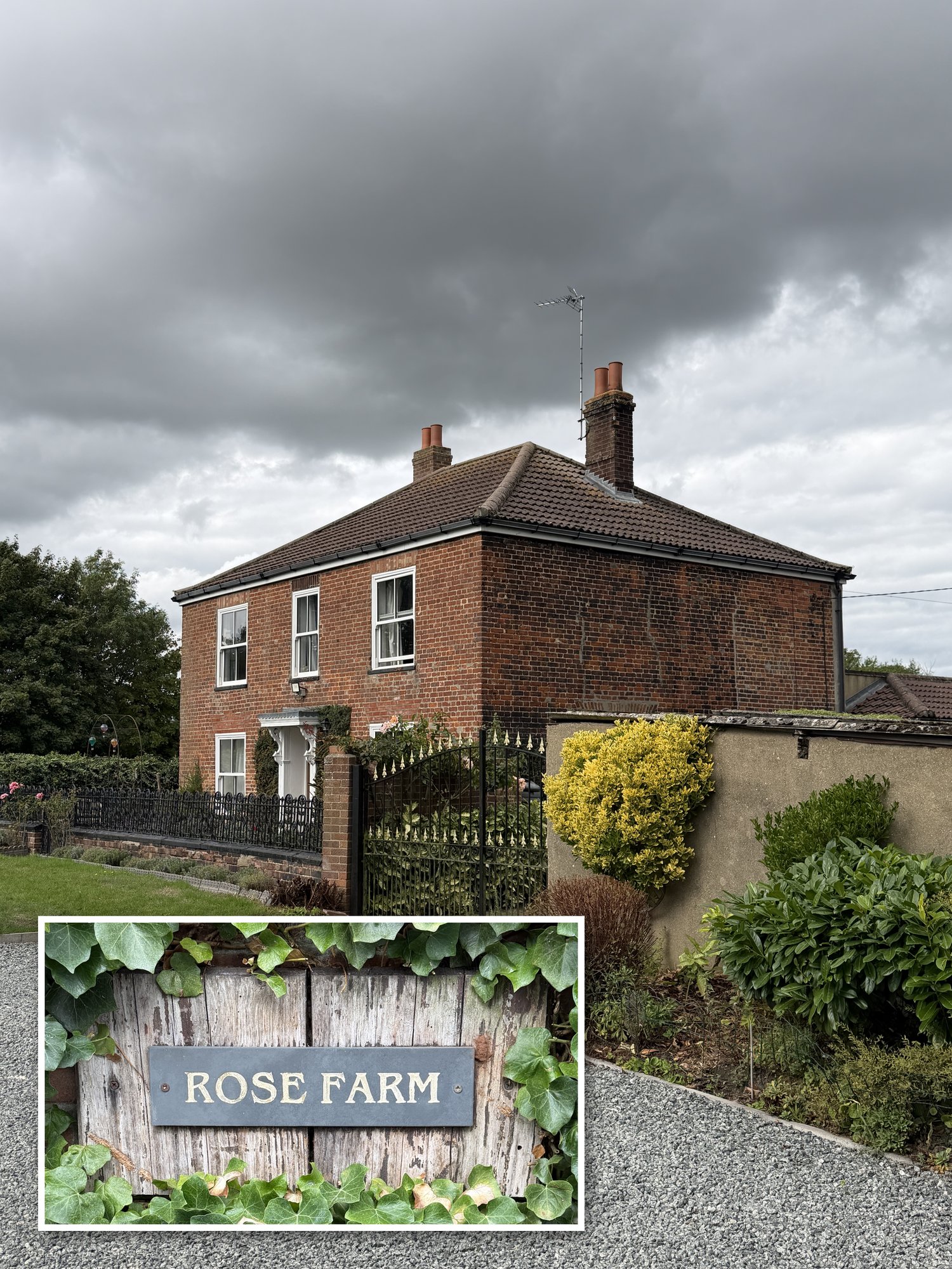 A two-storey red brick house with a tiled roof and chimneys behind iron railings and a gate, beyond a gravel drive, under heavy grey cloud. An inset shows a slate sign reading Rose Farm on a wooden board among ivy.