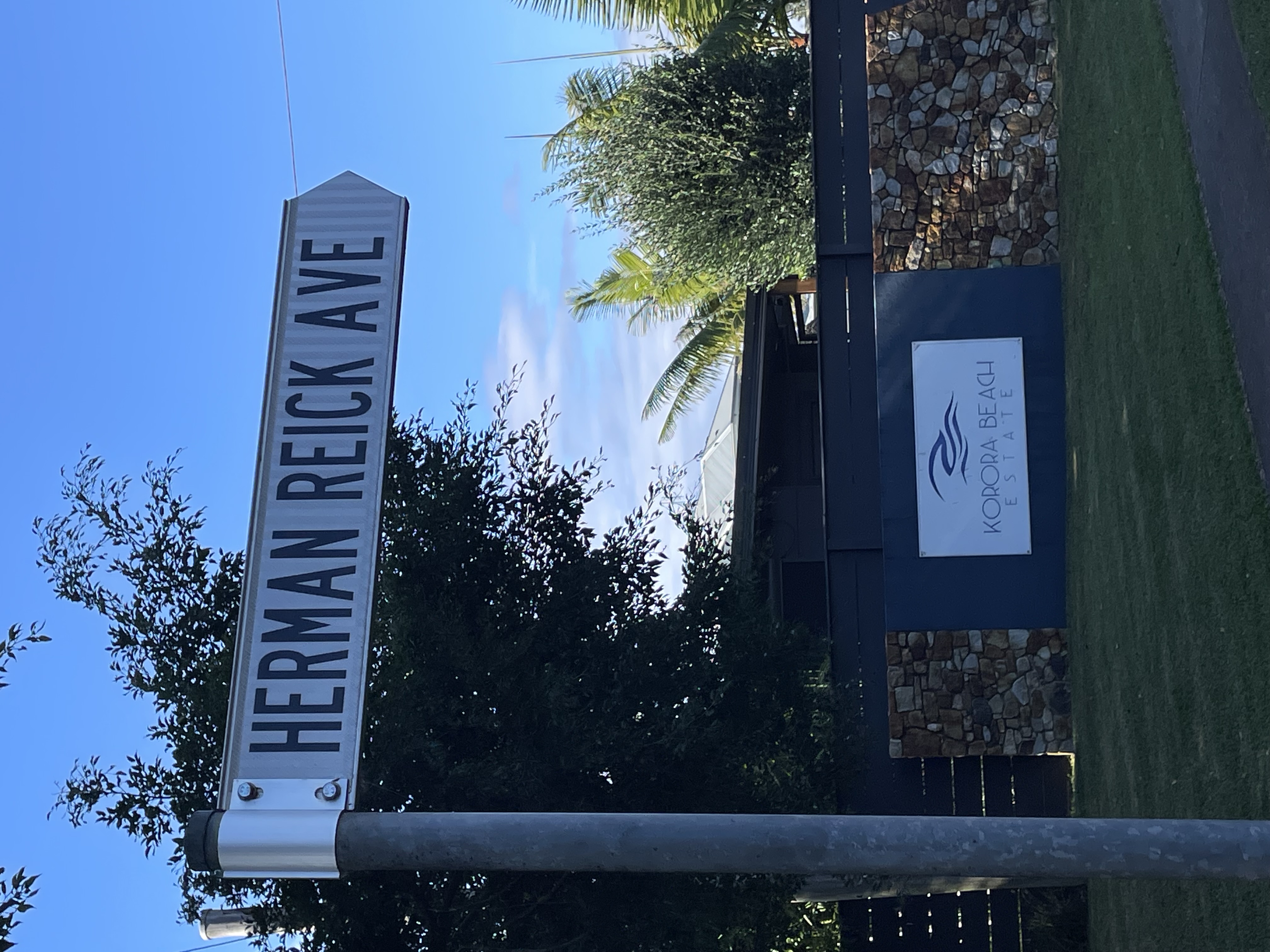 Street sign reading HERMAN REICK AVE, at the entrance to Korora Beach Estate, Coffs Harbour